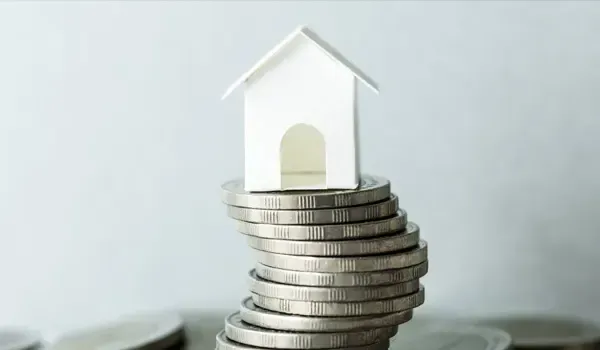 Casa en miniatura sobre una pila de monedas, simbolizando ahorro en hipoteca en La Rioja